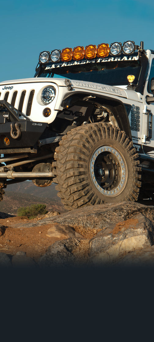 Jeep Wrangler on a rocky trail with Rocktrix beadlock wheels on large mud-terrain tires